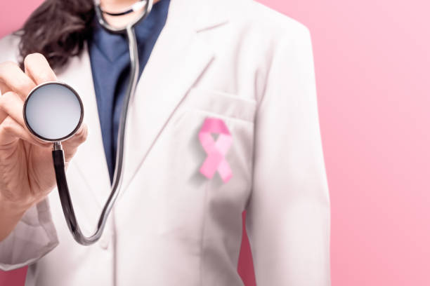 istock A woman doctor in a white lab coat using with pink ribbon using a stethoscope over pink background 1175678622