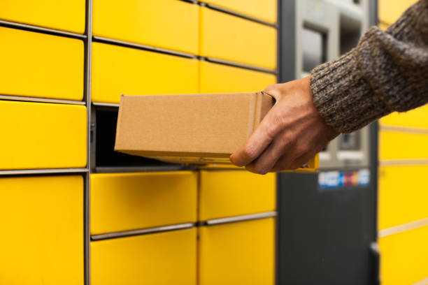 Self-service post terminal machine. Man recieve a parcel Yellow self-service post terminal machine. Man recieve a parcel street post stock pictures, royalty-free photos & images