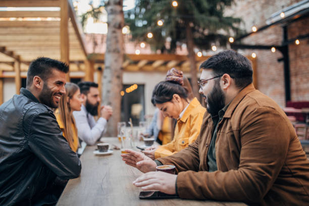 istock Group of friends sitting outdoors in pub 1175680026