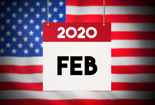 Calendar standing in front of the American flag and showing February 2020 Stock Image