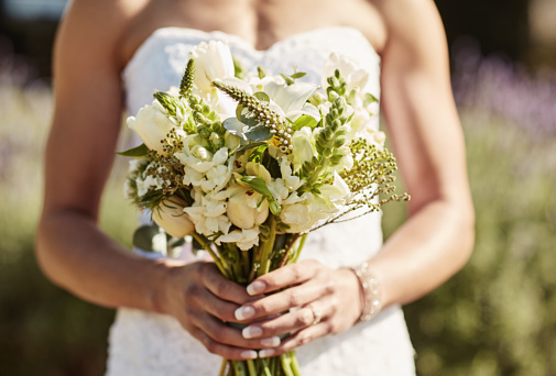 bride in white dress holding tenderness bouquet of roses. Selective focus