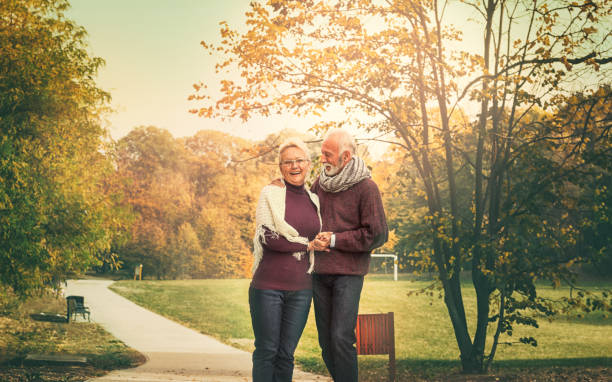 istock Happy senior couple walking through city park 1175683036