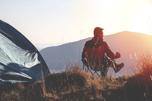 A man camping on mountains feels comfortable stock photo