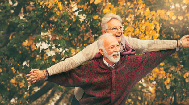 楽しみを持っている幸せなシニアカ�ップル - senior adult fun autumn senior couple ストックフォトと画像