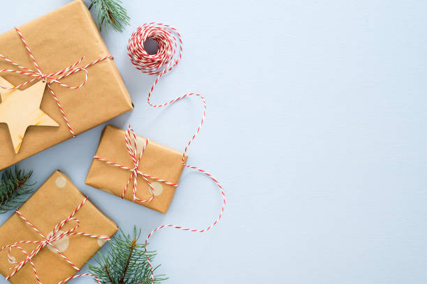 耶誕節或冬季的組成。框架由禮品盒包裹牛皮紙，繩繩，木質聖誕裝飾，杉樹樹枝在柔和的藍色背景。耶誕節，冬天，新年概念 - 渡假 圖片 個照片及圖片檔