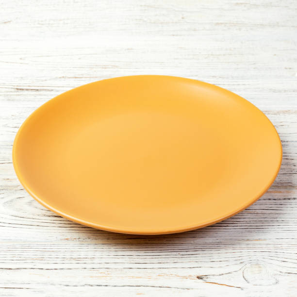istock Yellow Round Plate on wooden table background. Top view, template for your design 1175686196