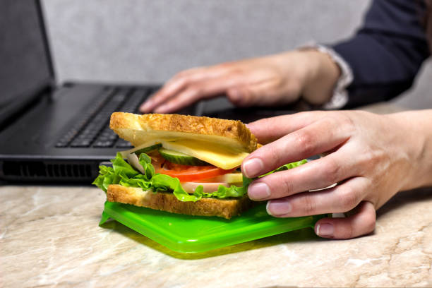 istock The girl is preparing for dinner at work, pulling out a sandwich, close-up 1175687646