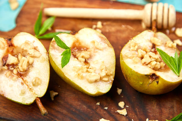 istock Tasty roast pears with honey and walnuts on wooden board on blue background table. 1175688024