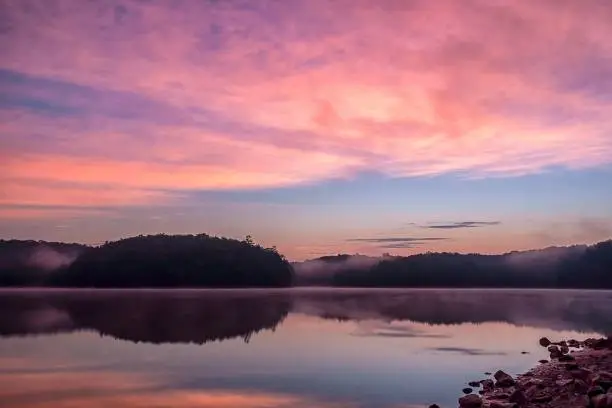 Dramatic sky over a serene lake just before sunrise