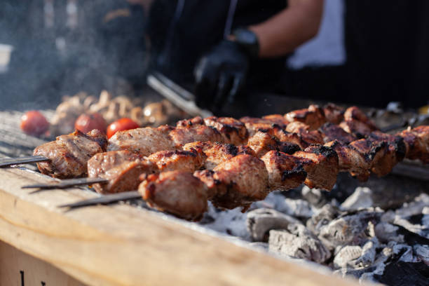 istock Meat on a skewer is fried on hot charcoal on an iron barbecue. 1175689024
