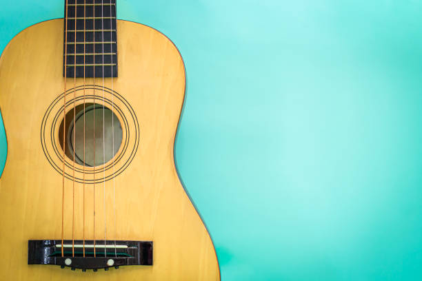 istock Acoustic guitar resting against a green background detail object 1175689469