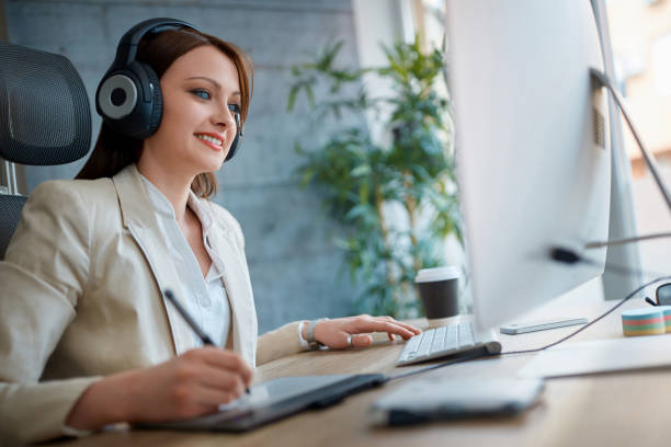 istock Woman graphic designer working in office with headphones 1175689576
