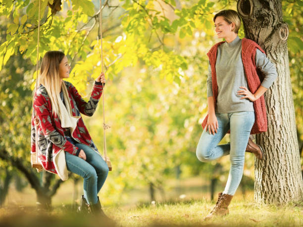 istock Two girlfriends outdoors in a public park together 1175689677