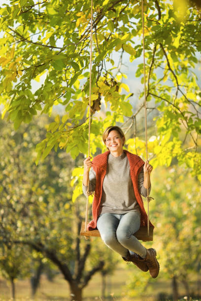 istock Beautiful young woman smiling on a swing 1175690881