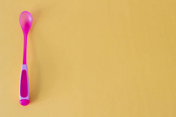 istock Baby spoon for feeding on a yellow background 1175691345