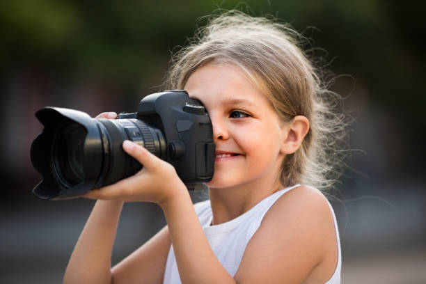 istock girl  holding photo camera 1175692103
