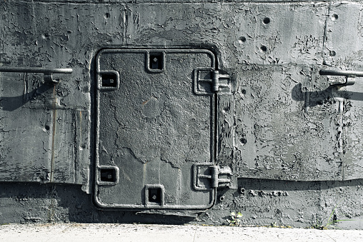 Close-up gray parts old submarine, sheets metal, closed door, background texture