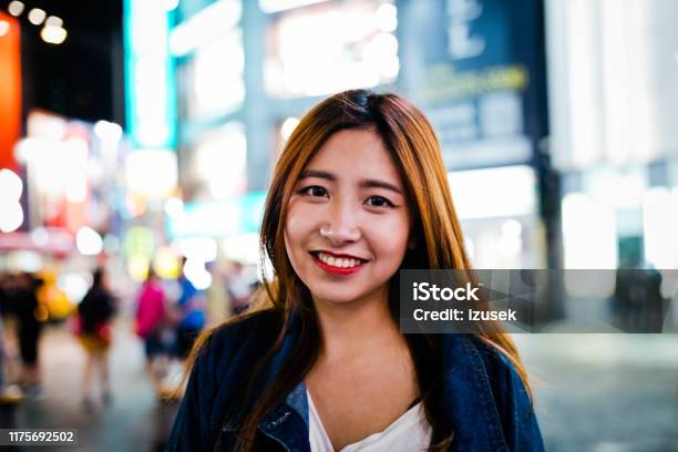 Portrait Of Smiling Young Woman In City At Night Stock Photo - Download Image Now - 20-24 Years, Adult, Adults Only