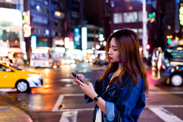 istock Woman using mobile phone while crossing street 1175692865