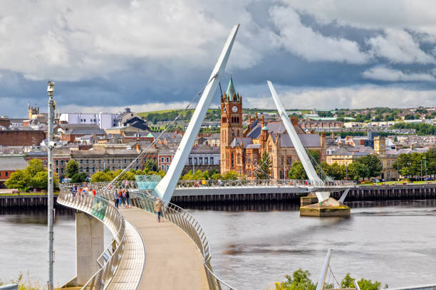 The Peace Bridge and Guildhall in Londonderry / Derry in Northern Ireland View over the River Foyle to the Guildhall and the Peace Bridge in Londonderry northern ireland photos stock pictures, royalty-free photos & images