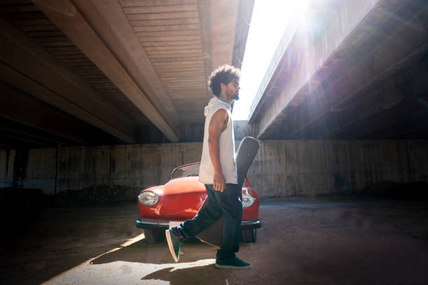 Ethnic young guitar man walking to  rehearsal or show with red generic convertible car edited vehicle to modify the original model