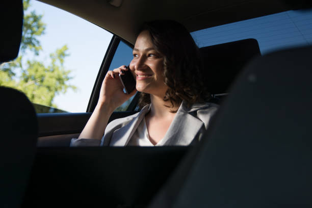 istock Smiling businesswoman using smart phone in the car 1175694166