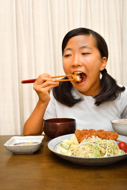 istock Japanese girl enjoys having dinner 1175697246