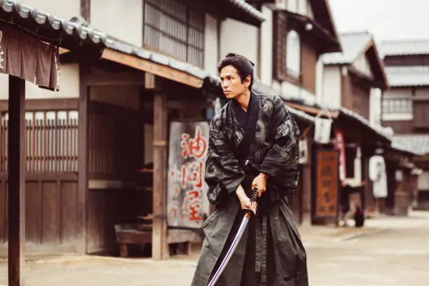 Man dressed as samurai holding samurai sword ready to fight