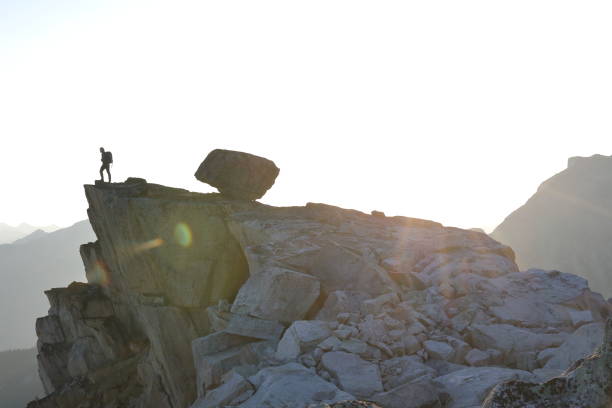 istock Male hiker ascends to mountain summit, sunrise 1175699012