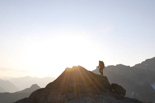 istock Male hiker ascends to mountain summit, sunrise 1175699061