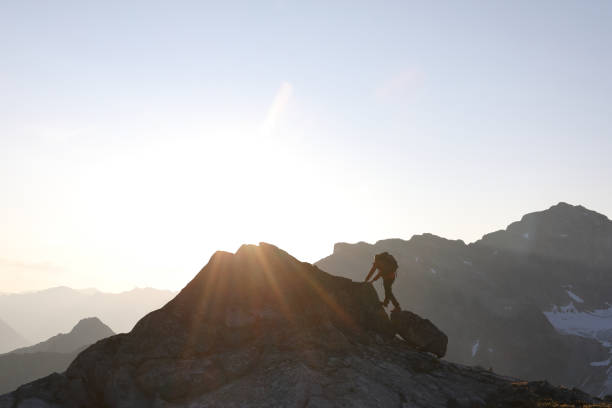 istock Male hiker ascends to mountain summit, sunrise 1175699073