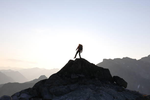 istock Male hiker ascends to mountain summit, sunrise 1175699085