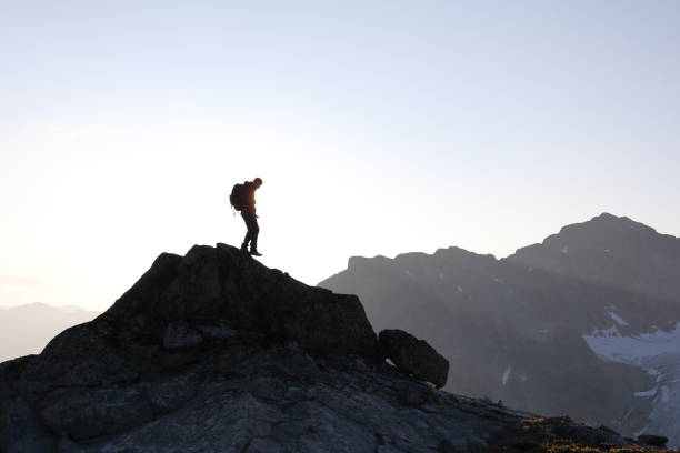 istock Male hiker ascends to mountain summit, sunrise 1175699252