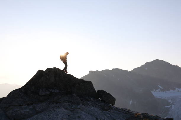 istock Male hiker ascends to mountain summit, sunrise 1175699302