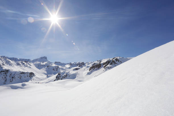 ver más allá de la colina nevada al sol y las montañas - blue outdoors nobody switzerland fotografías e imágenes de stock