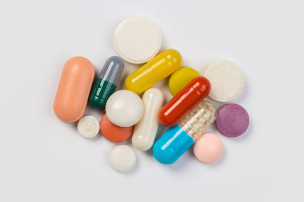 istock Assorted pharmaceutical medicine pills, tablets and capsules.Heap of assorted various medicine tablets and pills different colors on white background. 1175700534