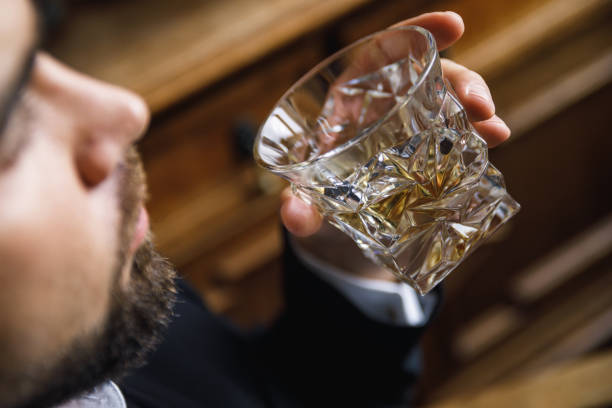 Man with a glass of expensive whiskey Bearded man with a glass of expensive whiskey glass of bourbon stock pictures, royalty-free photos & images