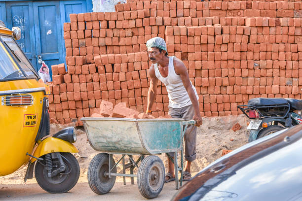 Coimbatore, India - October 09, 2016: Indian man or worker carrying bricks in a construction site in Tamil Nadu in India.