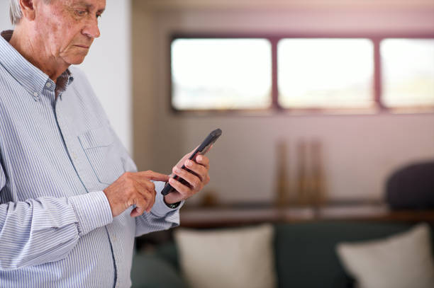 istock Senior Male on mobile phone concentrating and typing 1175703282