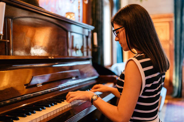 istock Young woman playing piano 1175706197