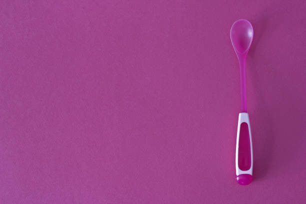 istock Children's spoon on a pink background 1175708194