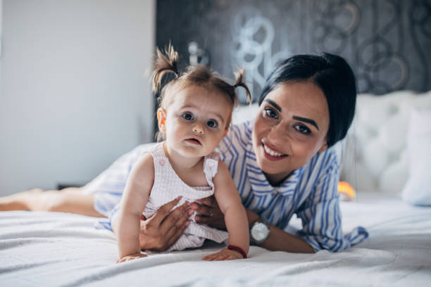 istock Beautiful baby and her mom relaxing in bed 1175709106
