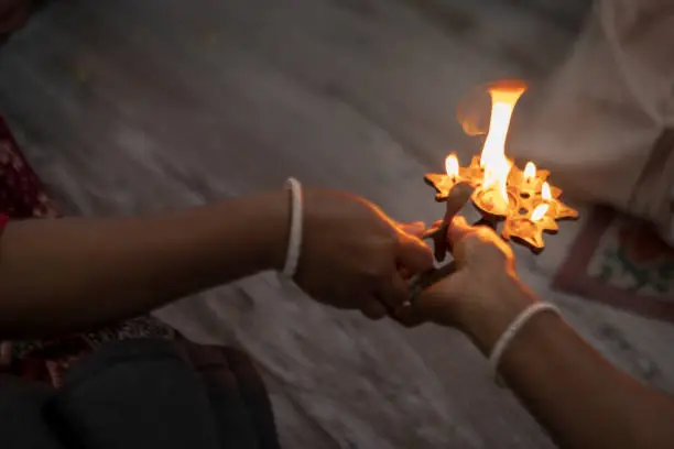 Burning oil lamp or pancha pradip with fire flame coming out - Background picture of Indian Hindu tradition & cultural ritual for worshiping god with copy space..