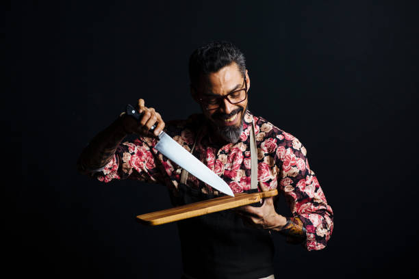 Portrait of a man with cutting board and butcher knife, isolated in a studio background Portrait of a man with cutting board and butcher knife, isolated in a studio background kitchen knife photos stock pictures, royalty-free photos & images