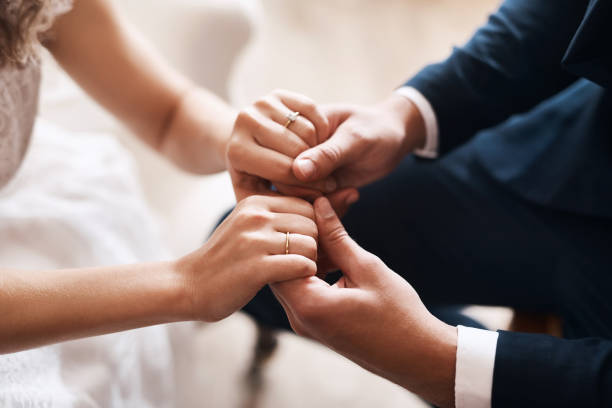 You are my today and all of my tomorrows Cropped shot of an unrecognizable newlywed couple affectionately holding hands after their wedding dinner jacket stock pictures, royalty-free photos & images