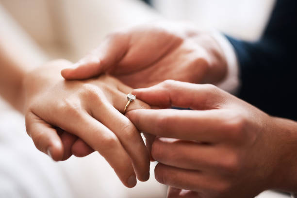 No diamond can compare to this precious love Cropped shot of an unrecognizable groom putting a diamond ring on his wife's finger during their wedding married stock pictures, royalty-free photos & images
