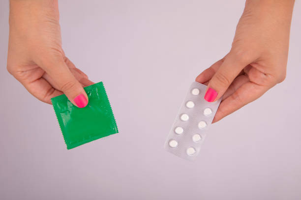 photo de préservatif et de pilules de contrôle des naissances - condom sex education contraceptive aids photos et images de collection