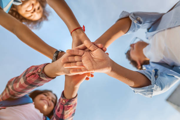 concepto de unidad. vista inferior de los niños pequeños que juntan sus manos en el interior - skilful hands fotografías e imágenes de stock