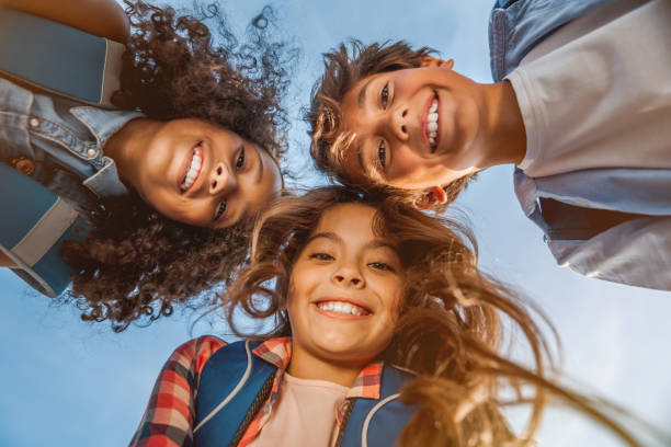 verticale des gosses d'école de sourire restant dans le cœrate à la cour d'école avec regarder dans l'appareil-photo - student caucasian bonding creativity photos et images de collection