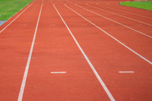 istock running track in stadium with green grass 1175712763